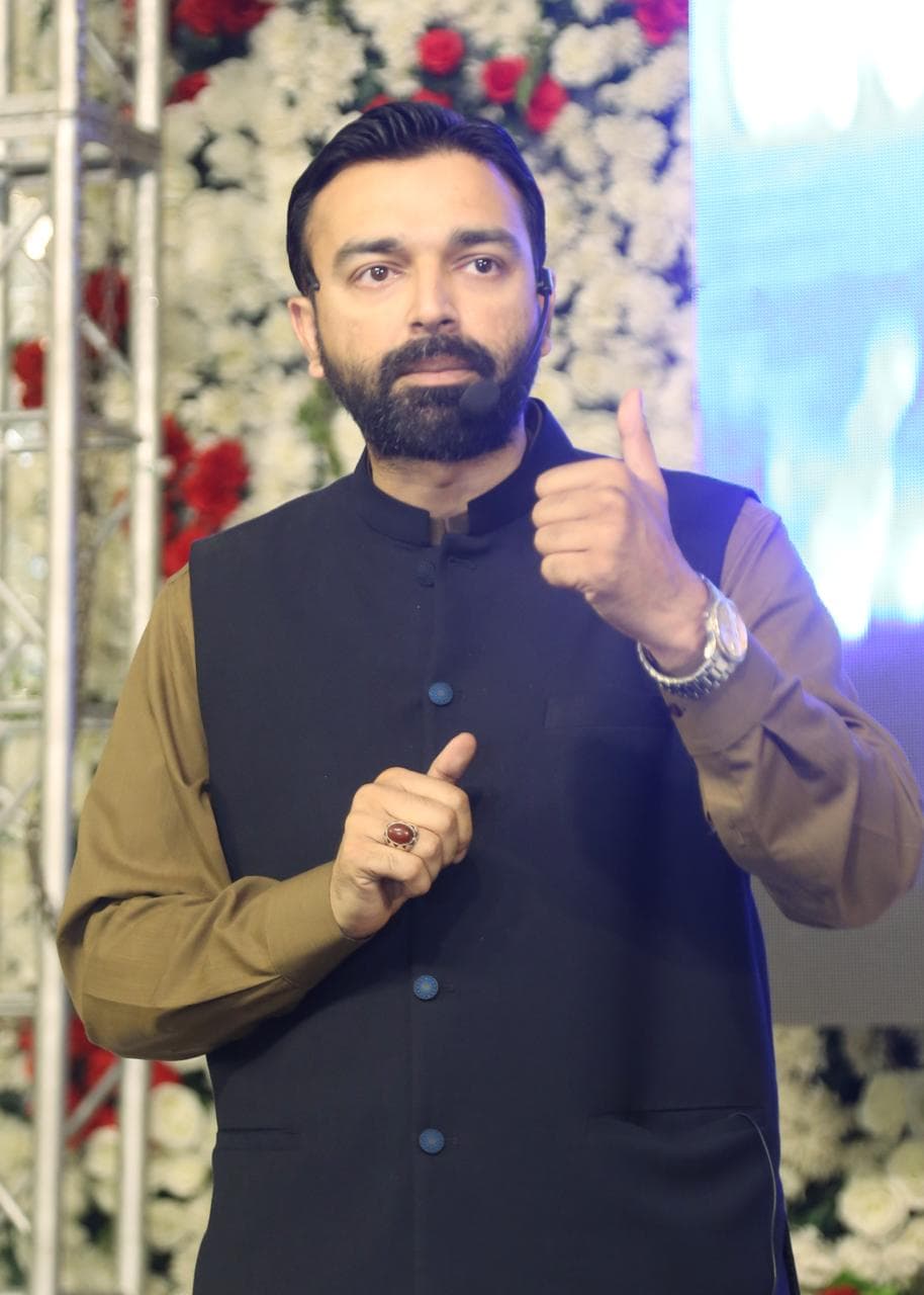 Sir Hasan Bari speaking to students with a headset microphone